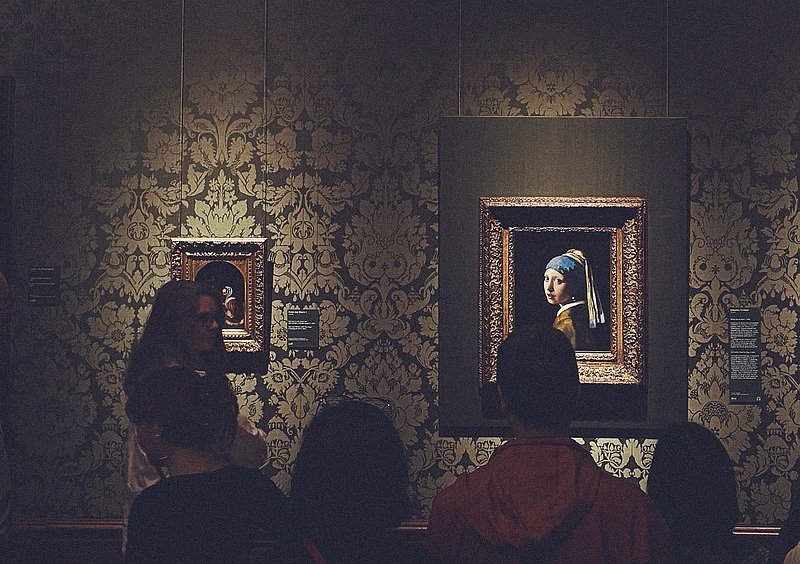 Besucherinnen betrachten Vermeers „Mädchen mit dem Perlenohrring“ im Mauritshuis in Den Haag.